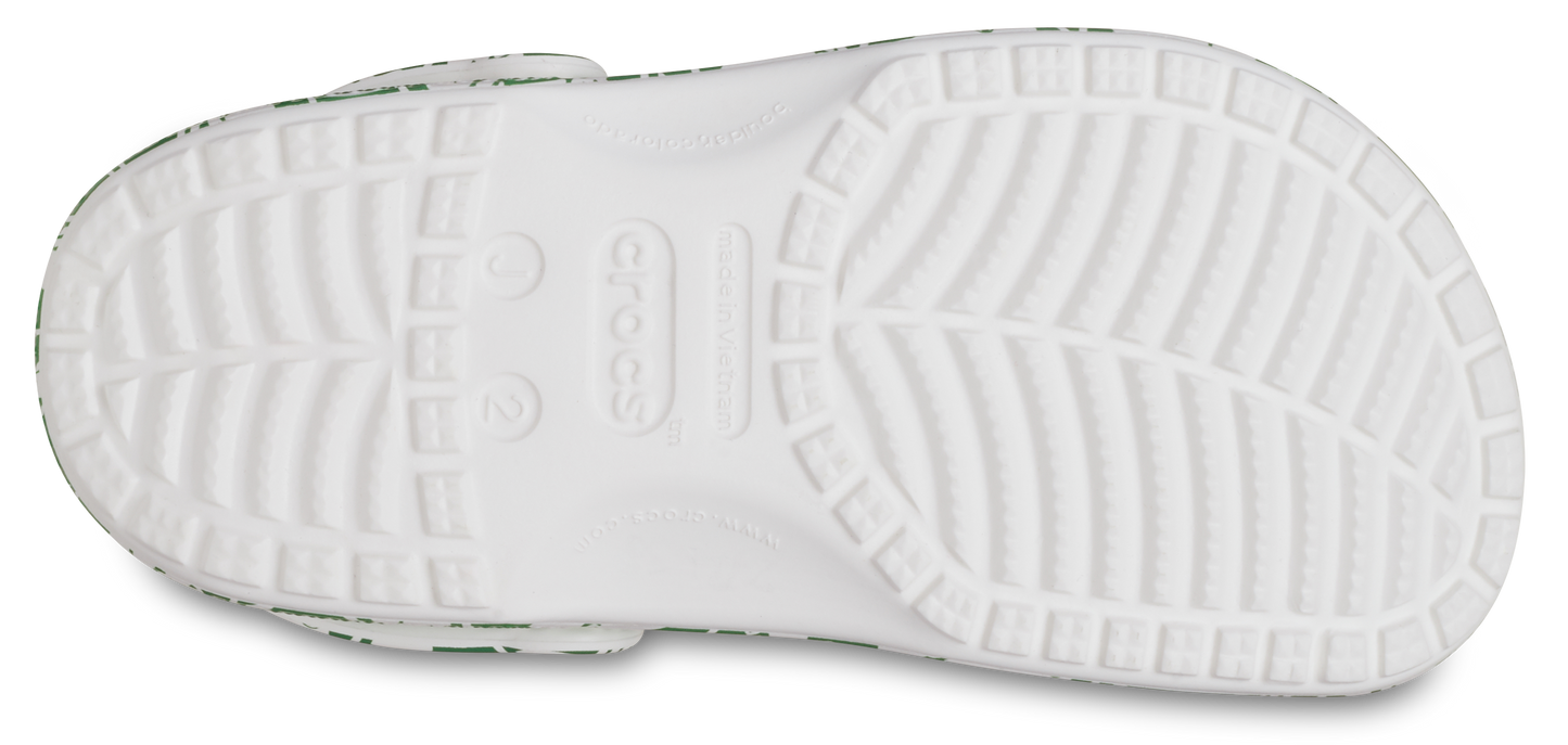 A pair of CROCS KIDS’ CLASSIC DUKE PRINT CLOG 210007-3WH in white and green colors, featuring a playful and fun design for children
