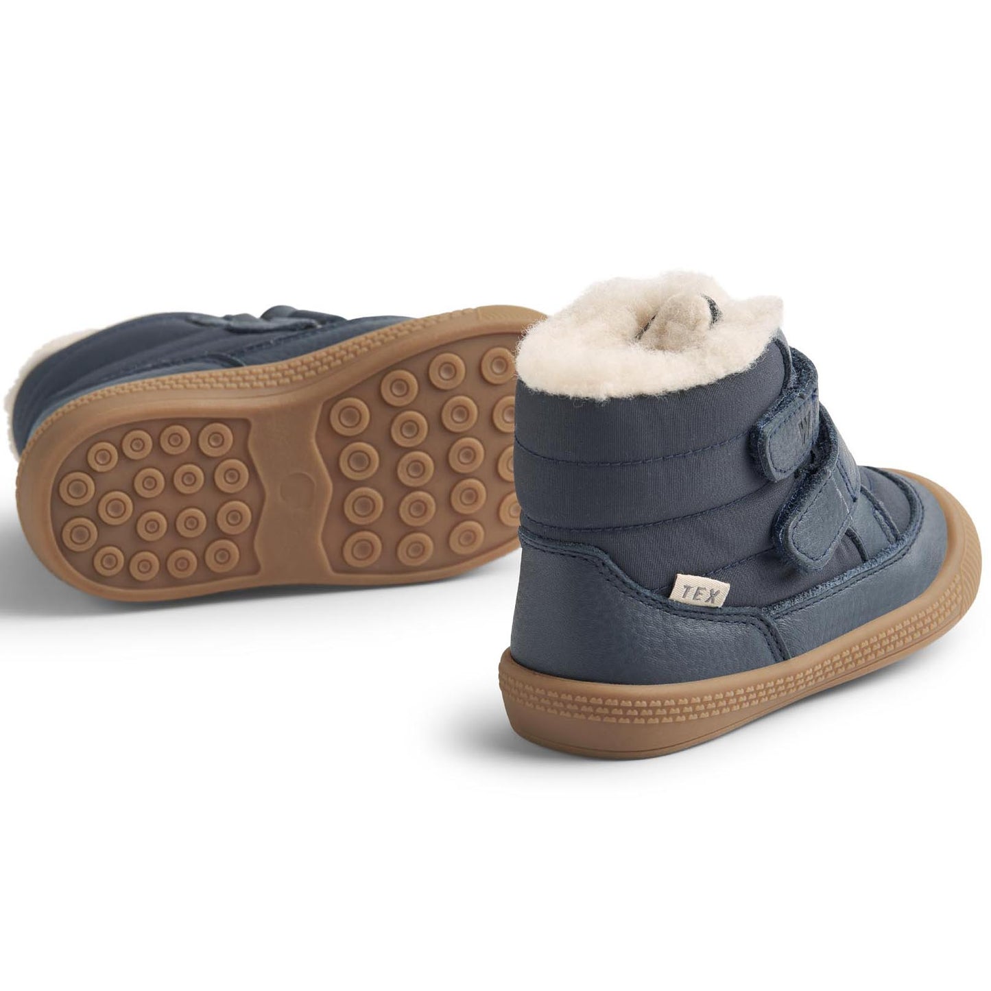 Child wearing the WHEAT TEX Stiefel DAXI WF320i - navy boots while playing in the rain and mud