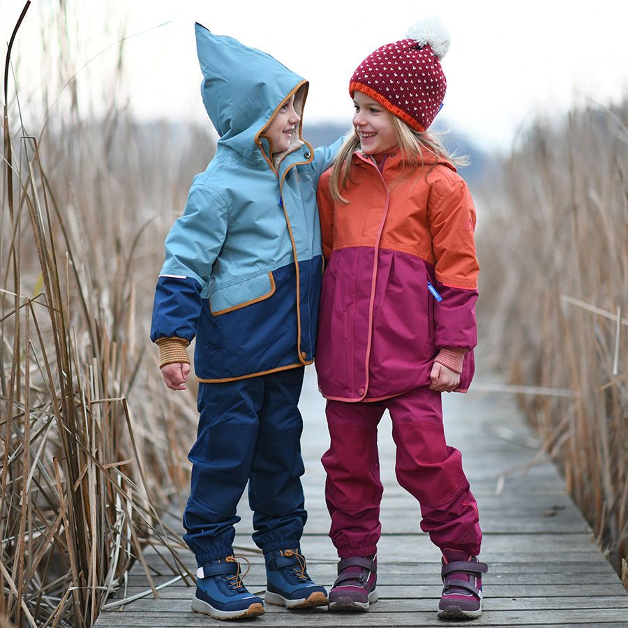 Child wearing FINKID TEX Knöchelschuh VUORI 7332037 - petrol while playing outside