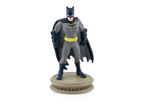 TONIES Figur Batman: Vorderansicht, grauer Anzug, gelber Gürtel, dunkle Cape, Batman-Logo, auf beiger Basis.