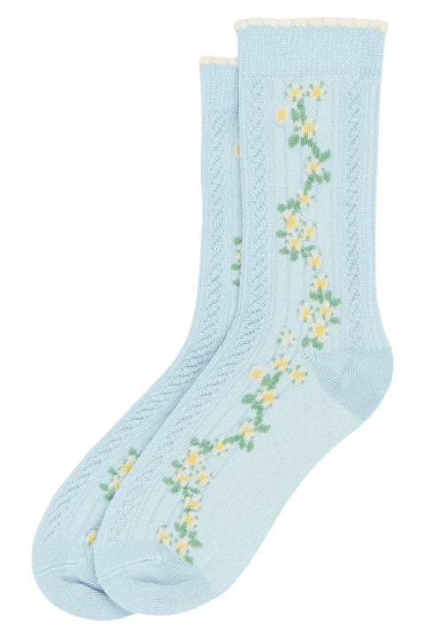 Vorderansicht zweier hellblauer Strümpfe mit gelb-weißen Blumenmuster.