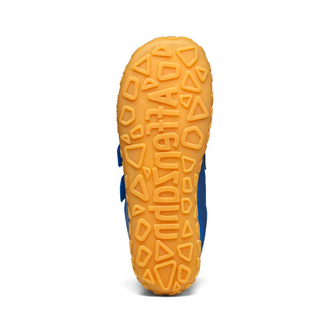 Kid's feet wearing AFFENZAHN Barfußschuh VEGAN DREAM - kornblumenblau while walking on grass field