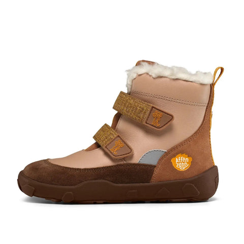 Seitenansicht eines AFFENZAHN TEX Stiefel; beige Leder, braunes Nubuk, weiße Fellkante, Klettverschluss, orange Patch.