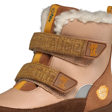 Seitenansicht eines AFFENZAHN TEX Stiefels aus Braun-Beige Leder mit gelben Klettbändern und flauschigem Innenfutter