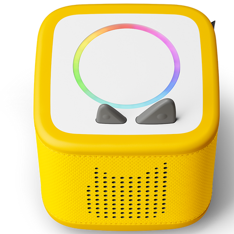 Vorderansicht einer gelben TONIES Toniebox; weiße Oberseite mit Regenbogenring, zwei graue Tasten, Lautsprecher-Gitter unten.
