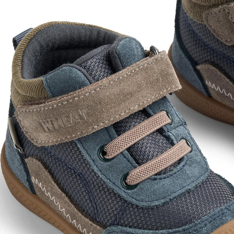 Nahaufnahme eines WHEAT Knöchelschuhs TODY WF705-01, Jeans/Grau/Oliv, Klettverschluss; sichtbare Obermaterial-Nähte.