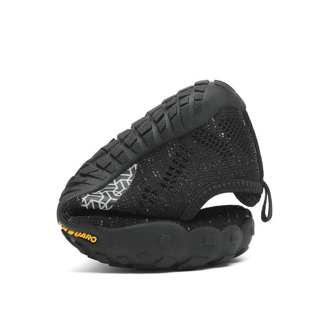 Seitenansicht eines schwarzen SAGUARO Barfußschuh KID SMART; gestricktes Obermaterial, grobe Profilsohle.