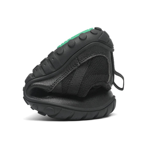 Seitenansicht des SAGUARO Barfußschuh BOA KID FORESTEP I in Schwarz, schwarzes Textilobermaterial, grüne Sohlenkante.