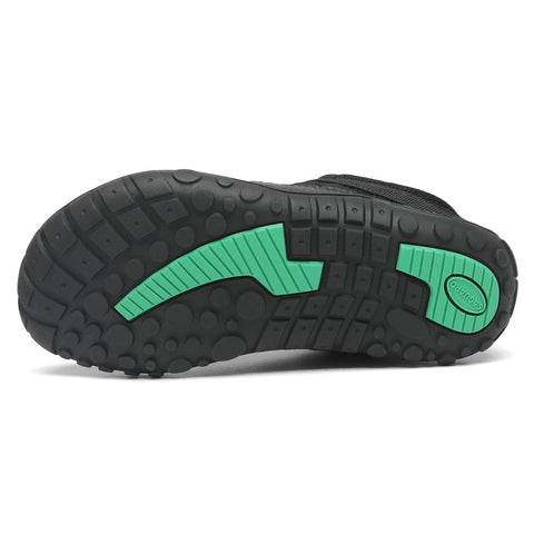 Unteransicht des SAGUARO Barfußschuh BOA KID FORESTEP I in Schwarz; schwarze Sohle mit grünen Akzenten.