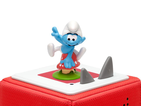 Die Schlümpfe Figur mit einem großen Schlumpfhaus im Hintergrund