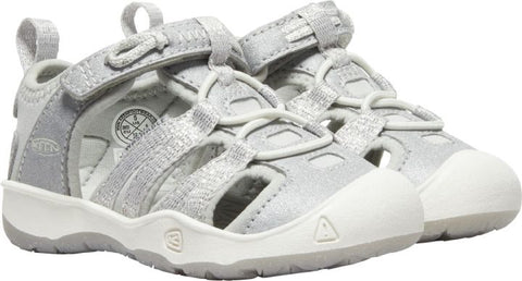 Toddler wearing silver KEEN Halbsandale MOXIE TOTS while walking on rocky terrain