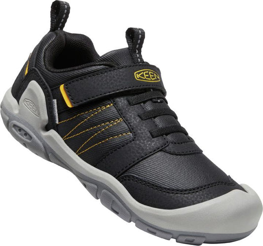 KEEN Halbschuh KNOTCH PEAK CNX - schwarz - gelb in action on a rocky trail, providing excellent grip and support for the wearer's feet