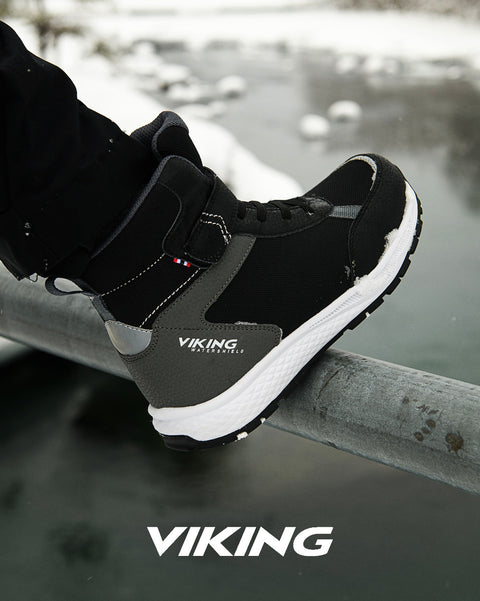 Pair of VIKING TEX Stiefel EQUIP WARM WP 1V - schwarz boots standing on icy ground, highlighting waterproof design