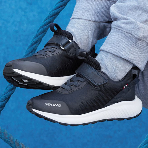 Person wearing VIKING GORE-TEX Halbschuh AERY TAU LOW GTX - schwarz shoes trekking through mud and water